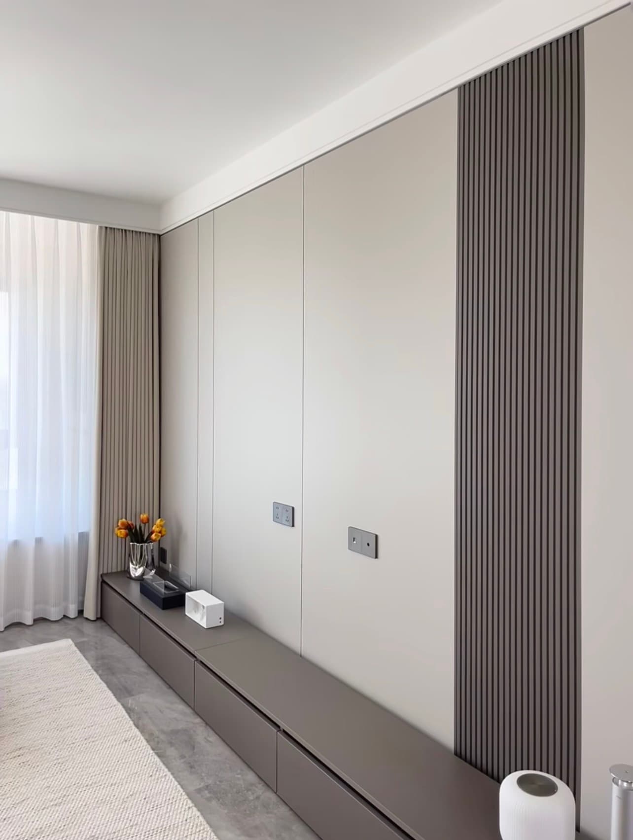Light bamboo-wood slat panels in a bedroom wardrobe wall